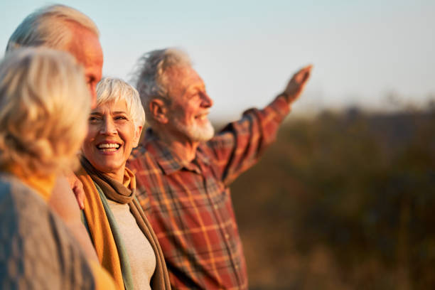 istock Happy mature friends communicating while enjoying in autumn day. 1390819696
