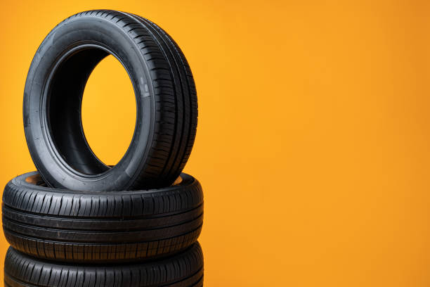istock Car tires isolated on yellow background, close up 1390819739