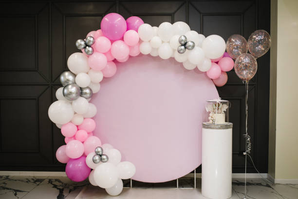 Arch decorated with pink, white and silver balloons. Baby shower party. Trendy Cake with a figure angel for a girl. Copy space. Celebration baptism concept. Birthday Cake on a background photo wall. Arch decorated with pink, white and silver balloons. Baby shower party. Trendy Cake with a figure angel for a girl. Copy space. Celebration baptism concept. Birthday Cake on a background photo wall. floral garland photos stock pictures, royalty-free photos & images