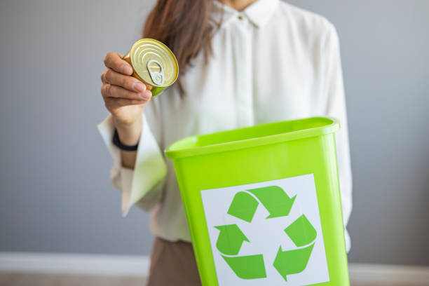 istock Woman putting a tin in the trash bin 1390821408