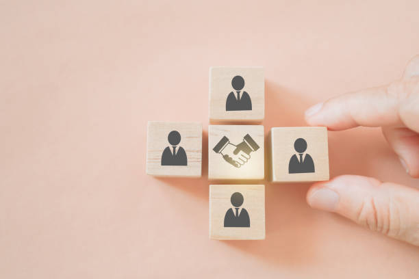 istock businessman's hand arrange wooden cube block with hand shake icon in middle for teamwork, brainstorming, cooperation for business growing concept 1390823762