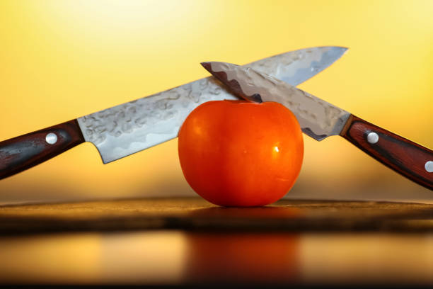 Knives and tomato Knives cutting tomato on the wooden board with yellow background knif stock pictures, royalty-free photos & images