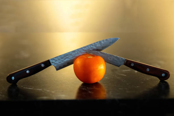 Knives and tomato Knives cutting tomato on the wooden board with yellow background knif stock pictures, royalty-free photos & images