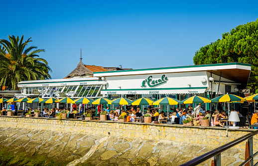 People eating on the terrace of l'Escale, a famous restaurant near the jetty of Belisaire in Cap Ferret in the Arcachon bay in France