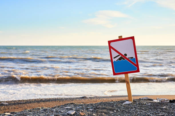warnung kein schwimmschild mit starker meereswelle am strandhintergrund - oahu water sand beach stock-fotos und bilder