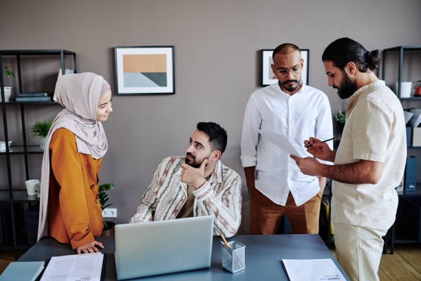 istock Group of young busy employees preparing for presentation by workplace 1390829343