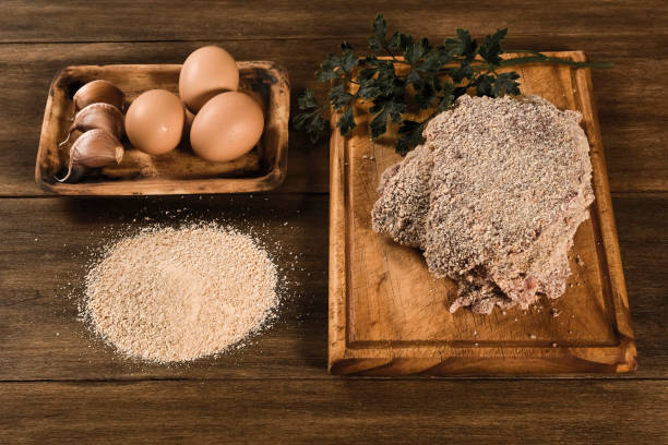 veal milanese presented on the table with ingredients - milanese imagens e fotografias de stock