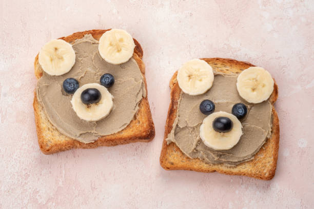 istock Funny children bear toasts with nuts butters for breakfast 1390832311