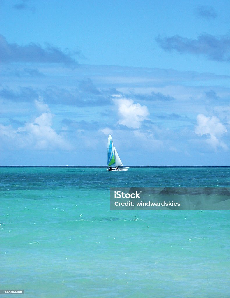 Sailing in a Tropical Breeze A gentle tropical breeze is perfect for sailing a catamaran over turquoise waters at Lanikai Beach, O`ahu, Hawai`i. Beach Stock Photo