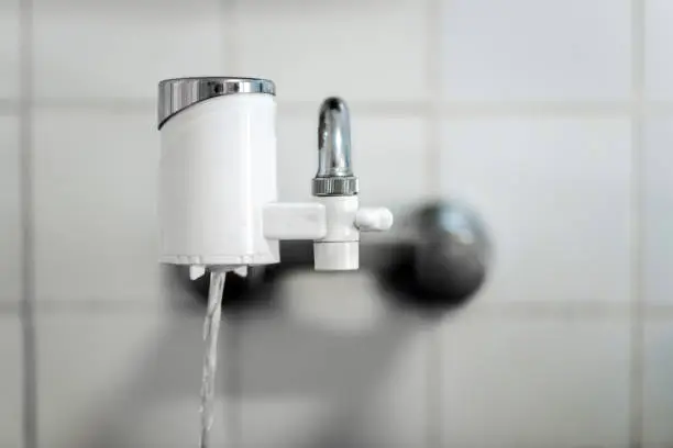 Water filter attached to a kitchen faucet. Filter that  purifies the water to be able to drink the water that comes directly from the tap.