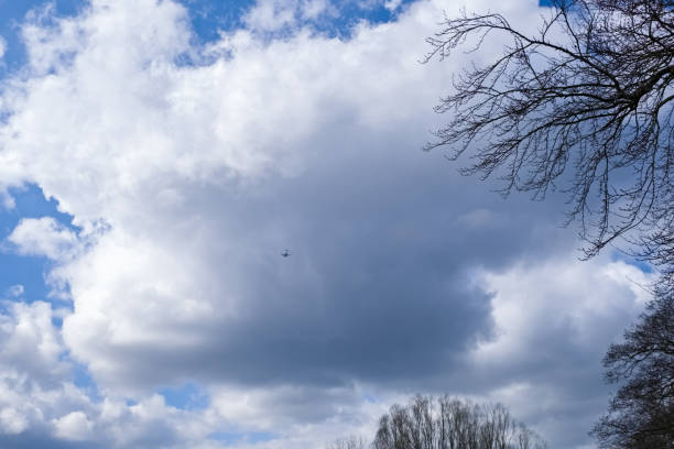 A scottish Sky with white and dark cloud as the small speck of a Aeroplane flys into dark cloud