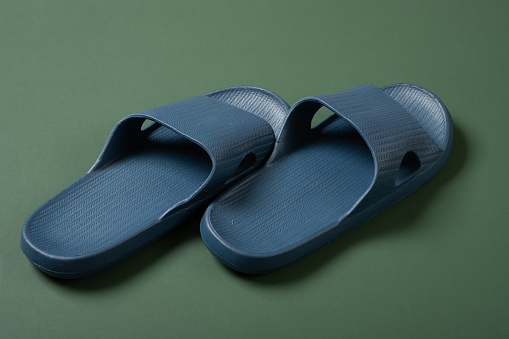 pair of blue plastic slippers on green background