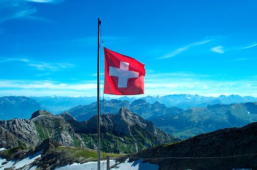 Swiss flag on the top of the mountain SÃ¤ntis in Switzerland near St.Gallen.