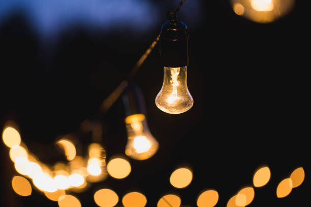 istock outdoor string lights hanging on a line in backyard. 1390836012