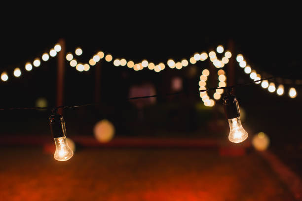 istock outdoor string lights hanging on a line in backyard. 1390836052