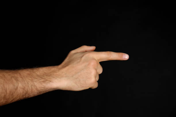 istock Man pointing at something on black background, closeup. Finger gesture 1390836307