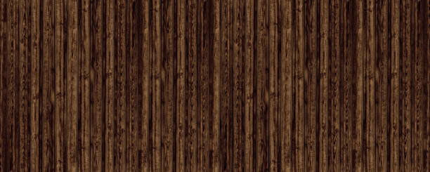 istock Dark brown shabby wooden board wide panoramic texture. Rough old knotty wood plank rustic large background 1390836616