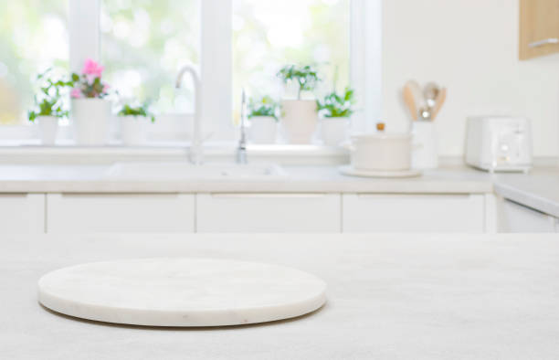 Pedestal for product on wooden table in blurred kitchen interior