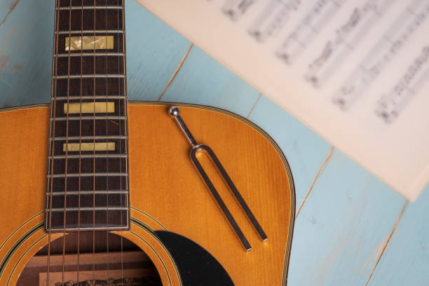 istock acoustic guitar tuning fork and music sheets on wooden background 1390840631