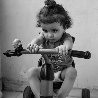 Cute little boy Shivaay driving cycle at home balcony during summer time, Sweet little boy photoshoot during day light, Little boy enjoy cycling at home during photo shoot Black and White