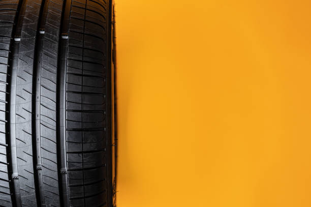 istock Car tires isolated on yellow background, close up 1390844040