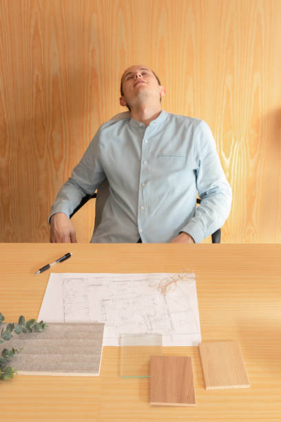 Sleepy young man working in interior design and architect studio office Sleepy and exhausted young man working in interior design and architect studio office man sleeping chair stock pictures, royalty-free photos & images