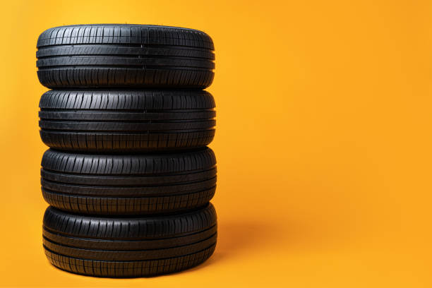 istock Car tires isolated on yellow background, close up 1390845005