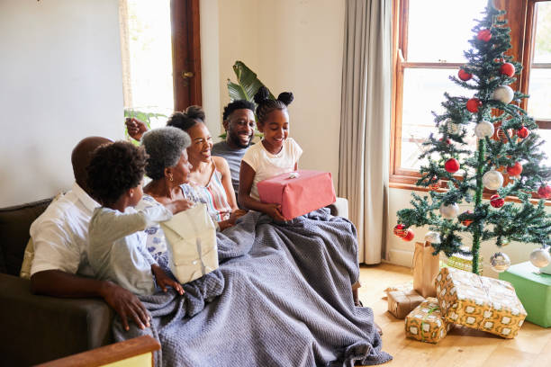 istock Multi-generation family smiling while opening presents on Christmas morning 1390848224