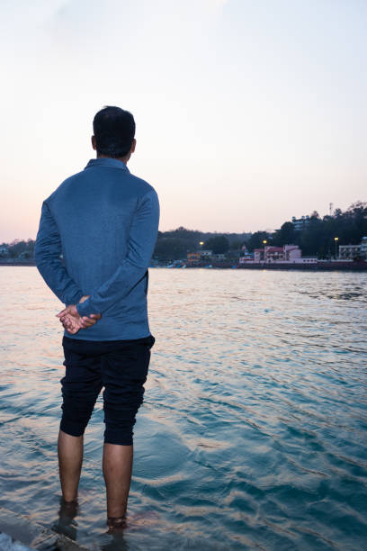 istock isolated young man standing at ganges river bank from flat angle 1390848398