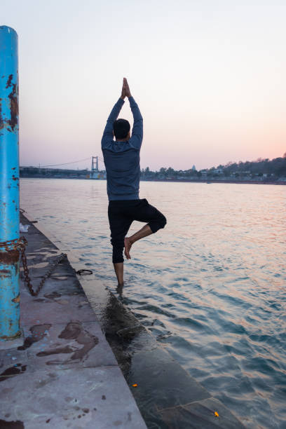istock isolated young man prying the holy ganges river at river bank from flat angle 1390848517