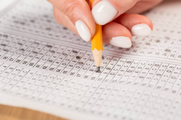 istock Close up of hands of student doing test. 1390848637