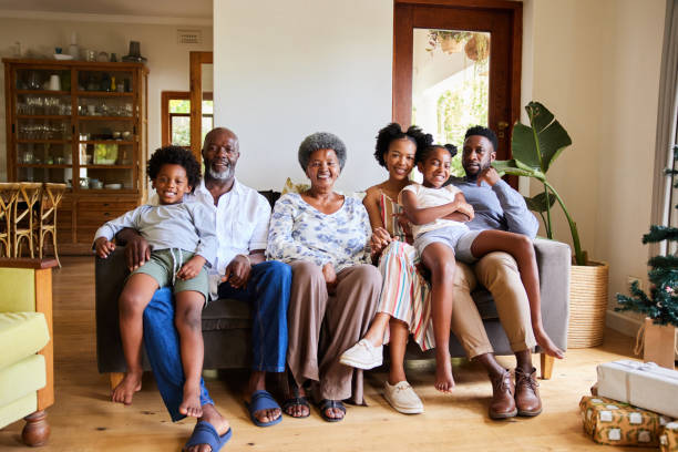 Smiling multi-generation family sitting at home on Christmas morning stock photo