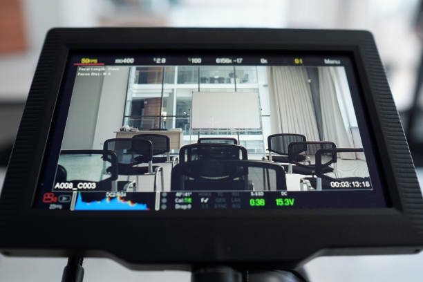 istock Display of video camera standing behind rows of chairs and whiteboard 1390852810