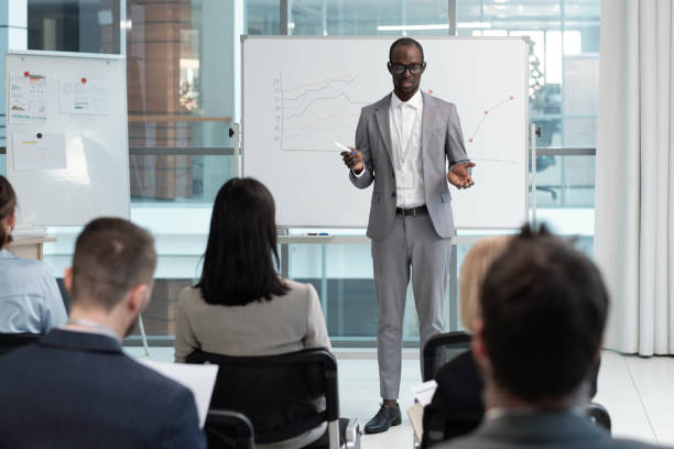 istock Young African American male coach explaining financial data to audience 1390852820