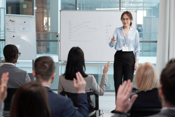 istock Confident speaker or business coach asking audience questions at seminar 1390852831
