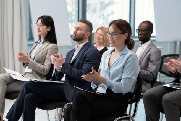 istock Several intercultural brokers applauding to speaker after presentation 1390852890