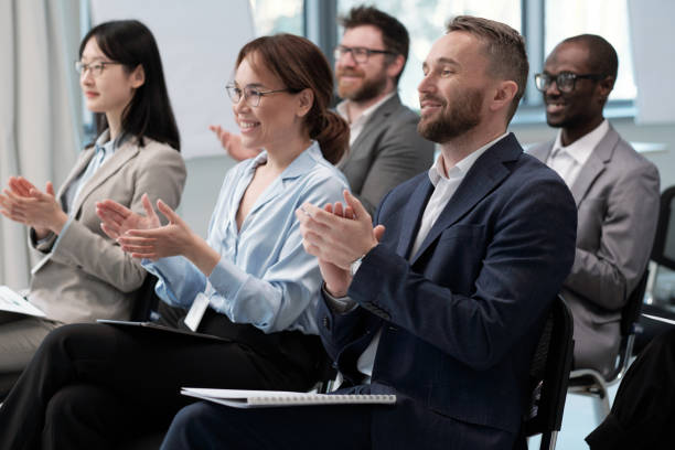 istock Two rows of happy employees clapping hands to speaker after presentation 1390852905