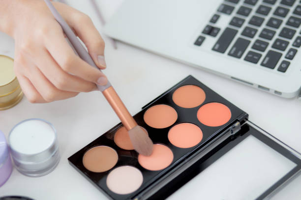 istock Hands of woman with learning makeup with brush on cheek on laptop computer with tutorial course online, female teaching and explain make up with makeup palette and cosmetic on streaming social media. 1390856758