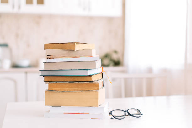 istock Stack of books with glasses standing on a table in front of the kitchen 1390857064