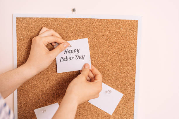 Woman's hands hanging sticker with the inscription happy labor day stock photo