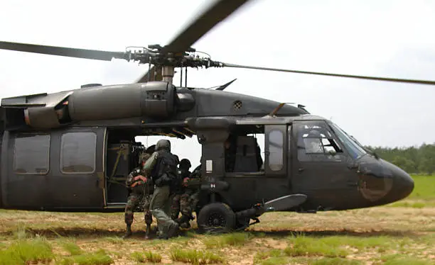 UH-60 Blackhawk landing on a dropzone to hot-load paratroopers for a jump.