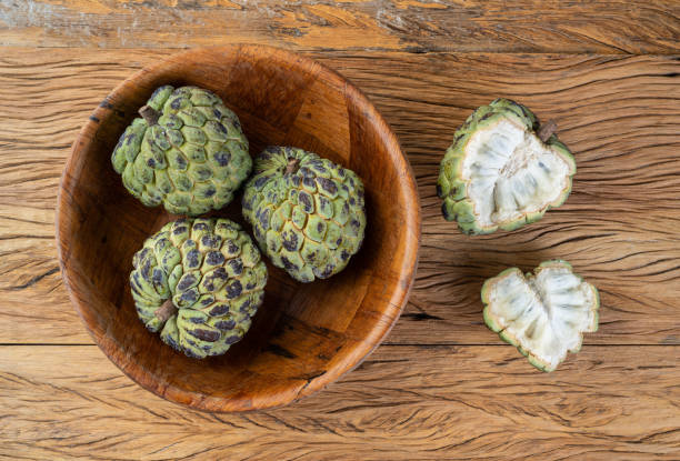 istock Sugar apples or custard apples in a bowl with cut fruit over wooden table 1390860037