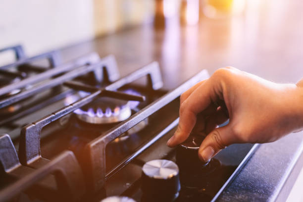 istock Hand turning on gas burner on kitchen stove top 1390860049