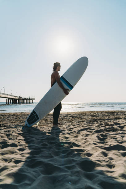 istock A man is standing on the beach with his surfboard 1390861662