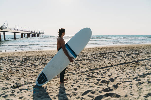 istock A man is standing on the beach with his surfboard 1390861668
