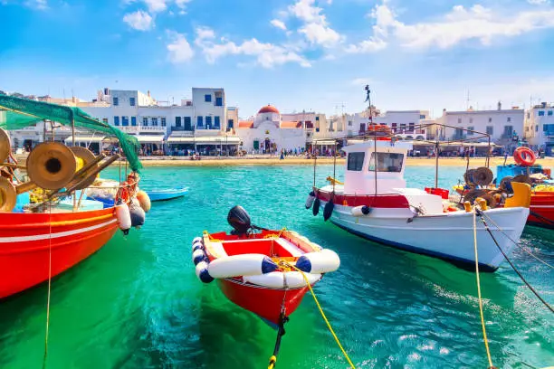 Photo of Chora port of Mykonos island with ships, yachts and boats during summer sunny day. Aegean sea, Greece