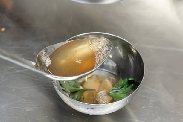 istock Cook with a large spoon pour the vegetables with broth 1390862720