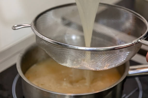 istock The cook pours boiling broth into a saucepan 1390862827