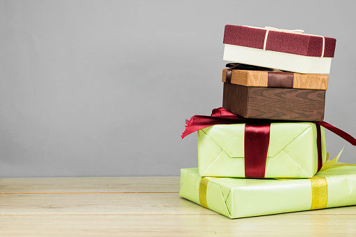 paper gift boxes stack on wood table. Festive Christmas / New Year holidays celebration concept