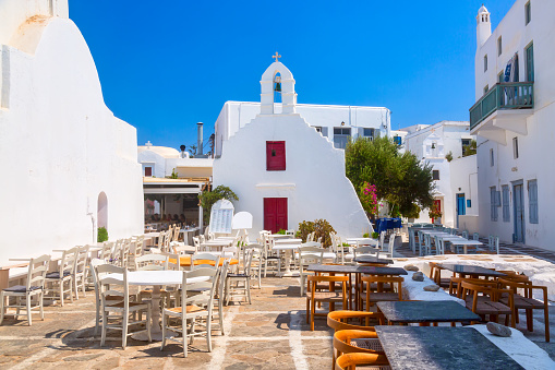 Famous old town narrow street with cafe and chapel. Mykonos island, Greece.